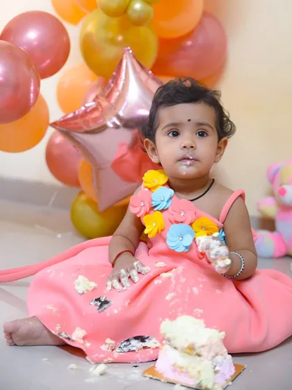 The mess is part of the fun! This cake smash photo captures the pure delight of a one-year-old digging into her first birthday cake.