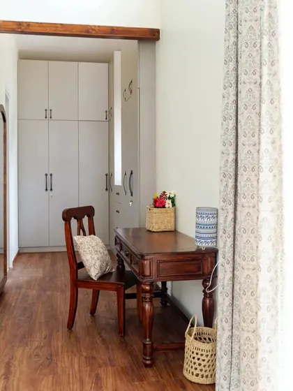 A cozy corner in the master bedroom with an ornate wooden desk and chair, creating a perfect spot for work or reflection. The walk-in closet is visible in the background.