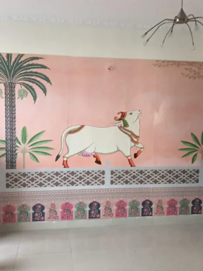 A beautiful Pichwai-style mural featuring a decorated cow (Nandi). This traditional Indian art form adds heritage and elegance.