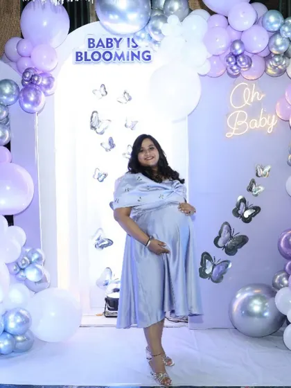 The glowing mom-to-be at her 'Baby is Blooming' butterfly-themed shower.