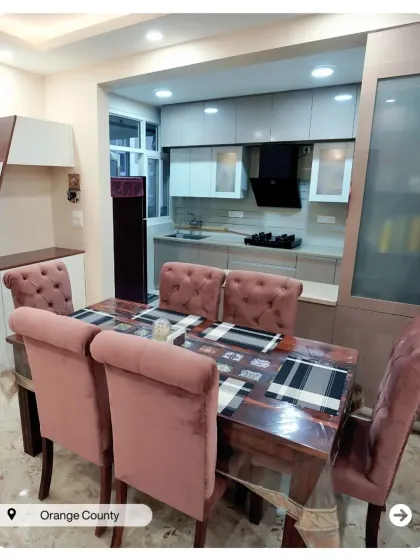 A compact dining nook adjacent to the kitchen. The plush pink chairs add a pop of color and comfort to the space.