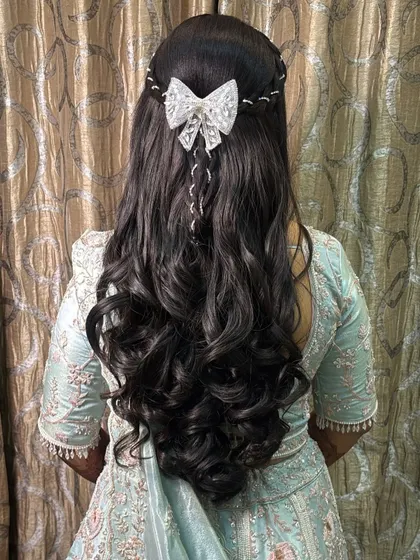 We also master modern hairstyles for receptions and parties. This elegant look with soft curls and a delicate bow is perfect for any celebration.