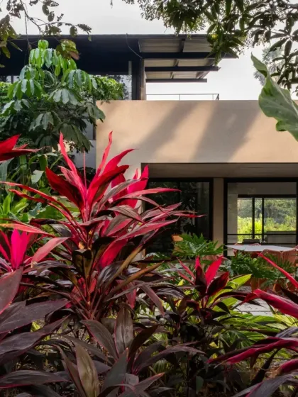 The vibrant red of cordyline plants contrasts with the muted tones of this Alibaug home. Our designs are always a response to the immediate site flora, sun path, and wind direction.