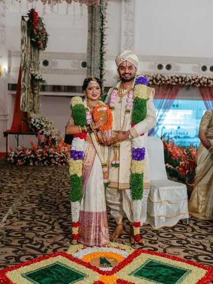 A full-length portrait of a lovely couple on their wedding day. I designed the groom's pure silk sherwani with hand embroidery to match the bride's traditional South Indian saree.