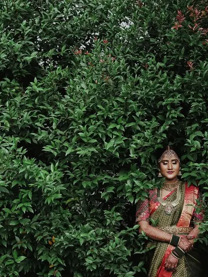 A duplicate of the serene bridal portrait against the green bush.