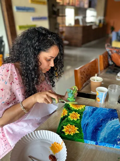 A participant using a palette knife to create flower petals. It's a fun and expressive technique.