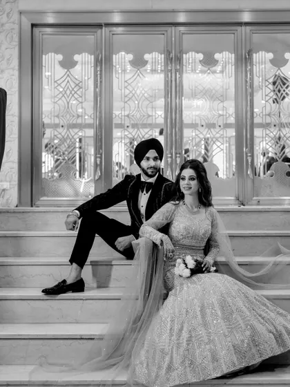 A timeless black and white portrait of the couple on the stairs, emphasizing their classic style.