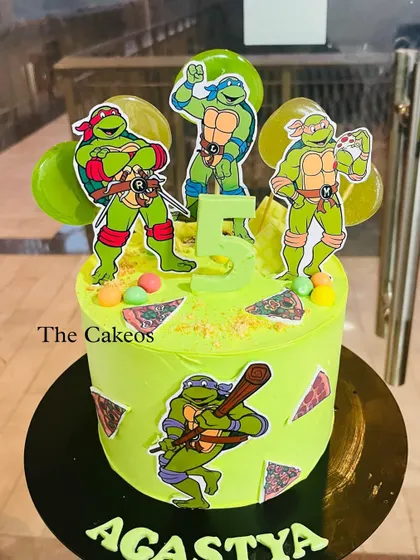 An action-packed Teenage Mutant Ninja Turtles cake. This bright green cake is decorated with character cutouts, fondant pizza slices, and is perfect for a 5th birthday party.