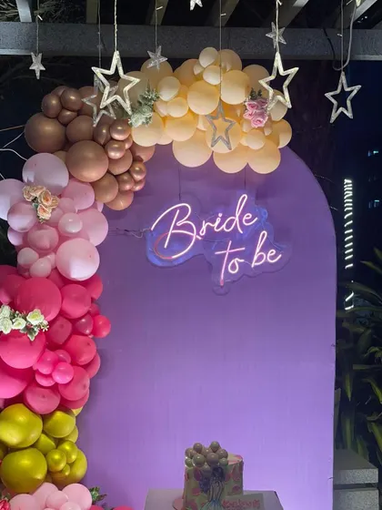 A close-up of the purple arched backdrop with the multi-colored balloon garland and "Bride to be" neon sign, perfect for capturing memories.