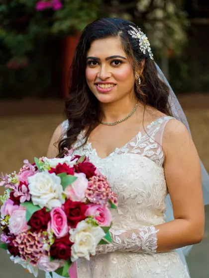 A close-up portrait with her bouquet. Her smile is the best accessory, enhanced by a makeup look that is soft, pretty, and timeless.