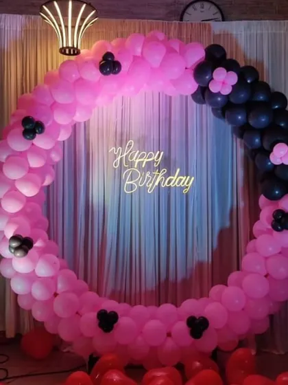 A playful pink and black balloon ring decoration. We added small black balloon clusters to the pink arch to create a fun, polka-dot-like effect.
