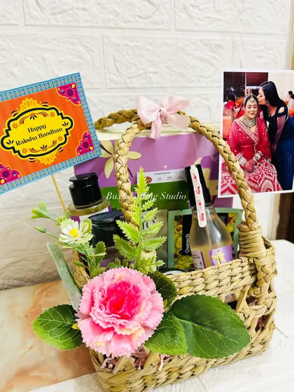 A beautiful Rakhi hamper for a sister, sent from Nepal to Delhi. It includes scented candles, Plum body care products, and is personalized with a photo.