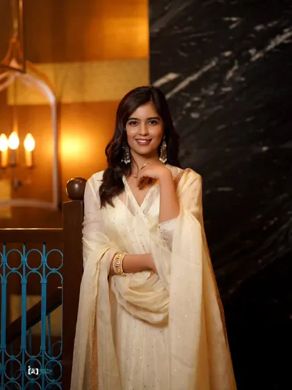This pose feels calm and composed. The soft lighting and elegant setting make this a sophisticated portrait in a beautiful traditional outfit.