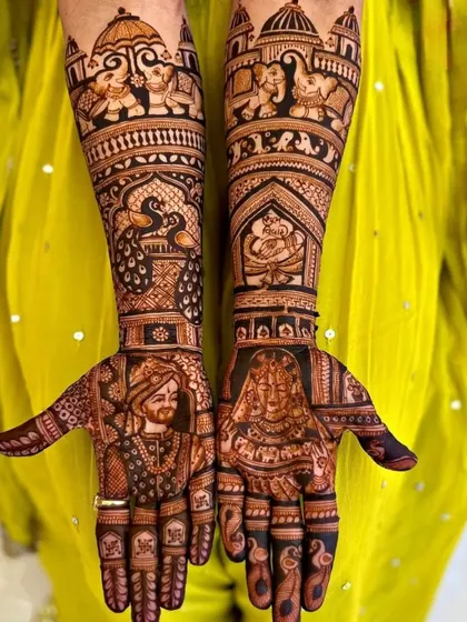 This design combines royal portraits of the bride and groom with classic Rajasthani elements. Notice the intricate peacock on the forearm and the elephants at the top.