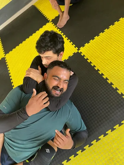 The moment before the tap. A student successfully applies a choke during a BJJ roll.