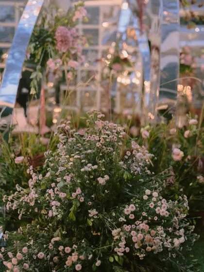 A close-up of the dreamy fresh florals used in the mirrored arch mandap. The soft textures and colors of the baby's breath and other wildflowers created a delicate contrast with the modern structure.