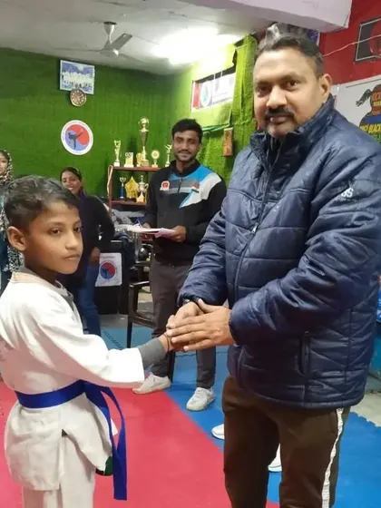 Congratulating another student on his promotion. His focus and discipline are growing with every class.