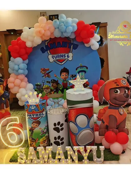 A Paw Patrol themed birthday decoration for a 6-year-old, with character cutouts and a colorful balloon arch.