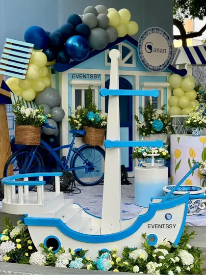 This shot highlights the themed props, including a miniature boat, a bicycle with a flower basket, and a wooden windmill.