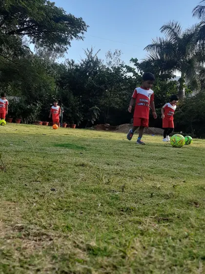 A young player dribbles the ball, showing the progress and skill development that happens in our classes.