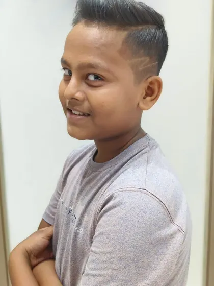 A young gentleman with a fresh cut, complete with a cool zigzag design on the side.