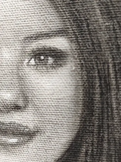 A macro shot of the Selena Gomez portrait, showing how the graphite and charcoal interact with the canvas weave.