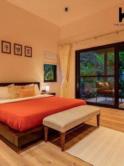 Another bedroom in the villa, designed with simplicity and comfort in mind, featuring a sliding glass door that leads to a private outdoor space.