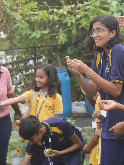 The joy and excitement of discovery. A teacher and students exploring the vegetable patch during a fun and educational outdoor session.