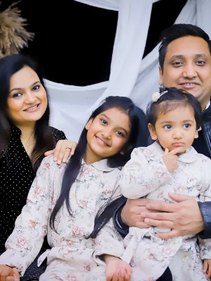 A beautiful posed shot of the family of four, with the little one looking curiously at the camera.