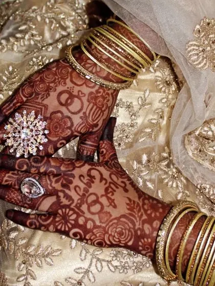 The final look of an engagement mehndi, complete with stunning jewelry. The dark stain looks beautiful against the bride's outfit.