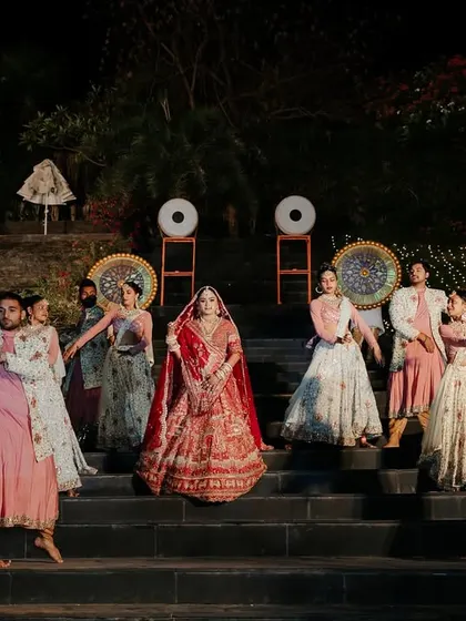 The bride makes her regal entrance, escorted by dancers, to the Varmala stage. Every element is choreographed to build anticipation for the grand moment.