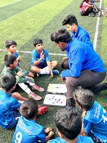 It all starts with strategy and teamwork. One of our coaches discusses tactics with the U-9 football team during a KSFA Youth Premier League match. We believe in educating the game, not just playing it.