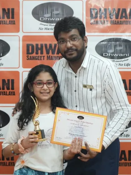 A teacher proudly presents an award to his student.