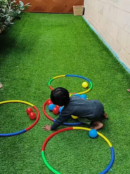 A young boy crawls through colorful hoops, learning about colors and shapes in a fun, physical way.
