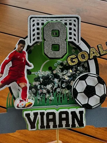 Goal. A close-up of our Cristiano Ronaldo shaker topper, complete with a soccer ball, net, and a confetti-filled shaker for an action-packed celebration.