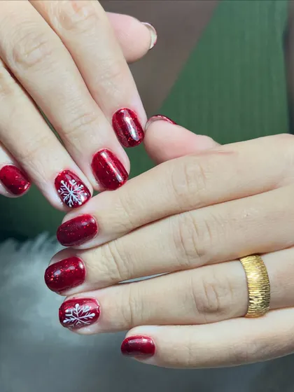 A full view of the sparkling red snowflake nails. This is a great option for someone who wants a touch of holiday spirit without a full set of intricate art.
