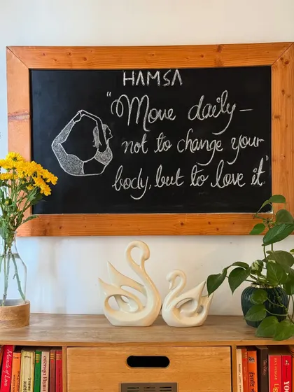 A daily reminder on our studio chalkboard: "Move daily, not to change your body, but to love it." This is the core philosophy of our practice at Hamsa.