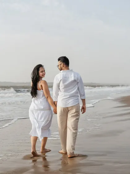 A candid shot of the couple taking a stroll along the shoreline. The way she looks back at him with a smile makes this such a sweet and spontaneous moment from their beach maternity session.