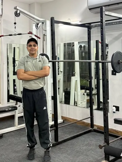 Arms crossed by the squat rack.