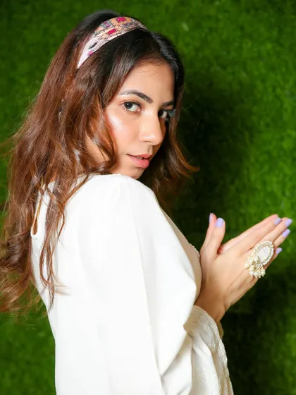 A profile view from the festive shoot, giving a better look at the model's hair, makeup, and the side profile of the outfit.