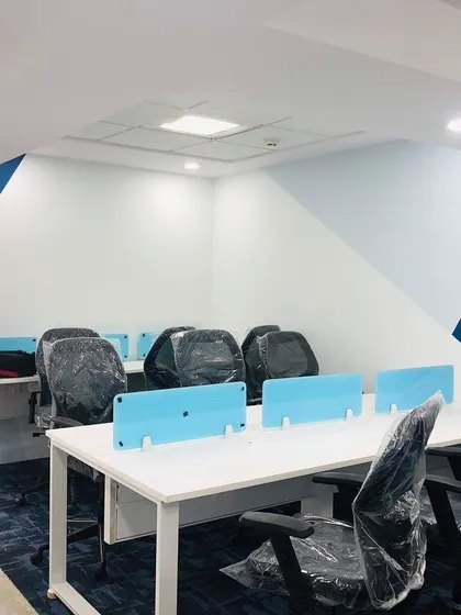 The actual completed office space, photographed during setup. This image shows how the final built environment faithfully matches the 3D render, from the wall paint design to the workstation layout.