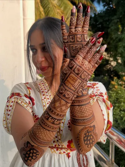 A happy bride showing off her intricate back-of-hand design, filled with personalized animal motifs.