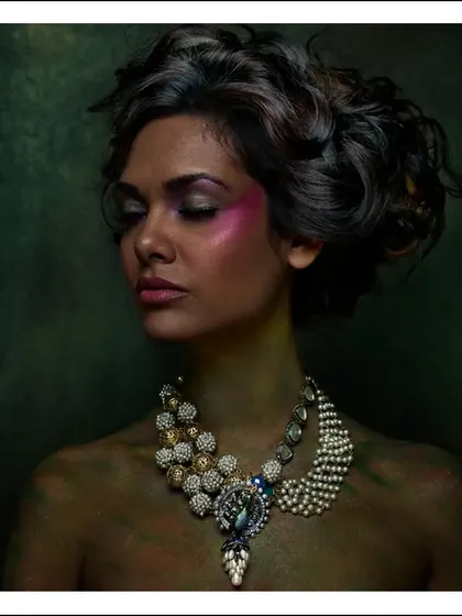 A painterly portrait where the model's skin is treated like a canvas. The soft lighting, rich colors, and elegant jewellery combine to create an image that feels like a classic painting.