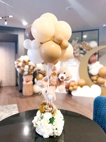 A whimsical centerpiece combining a teddy bear with a balloon bouquet. This is a perfect example of how I carry the party's theme through to the smallest details on every table.