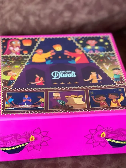 A vibrant pink 'Shubh Diwali' gift box with colorful illustrations, showcasing one of my festive packaging options for corporate orders.