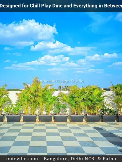 A clean and green border for a rooftop terrace. I used a series of identical planters with lush areca palms to create a natural privacy screen that adds a fresh, uniform look against the city skyline.