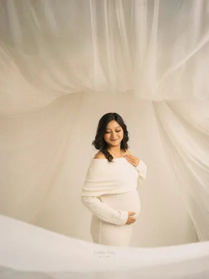 Wrapped in serenity and soft white fabrics, this portrait captures the quiet elegance of waiting. My minimalist sessions are perfect for mothers who desire a calm, dreamy, and timeless aesthetic, focusing purely on the beauty of the bump and the glow from within.