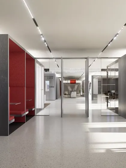 Bright red collaboration pods line the corridor of the Vian Office, offering vibrant, semi-private spaces for quick calls or focused work. The use of strong color in these functional zones adds energy without disrupting the overall calm of the main workspace.