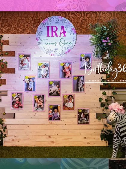 A personalized photo wall from Ira's jungle-themed first birthday, featuring pictures from her first year.