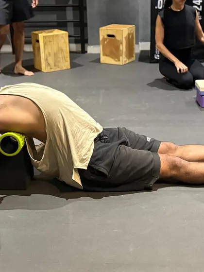 Using a foam roller on blocks to increase the range of my thoracic extension. This helps open up my upper back and improve my overhead mobility.